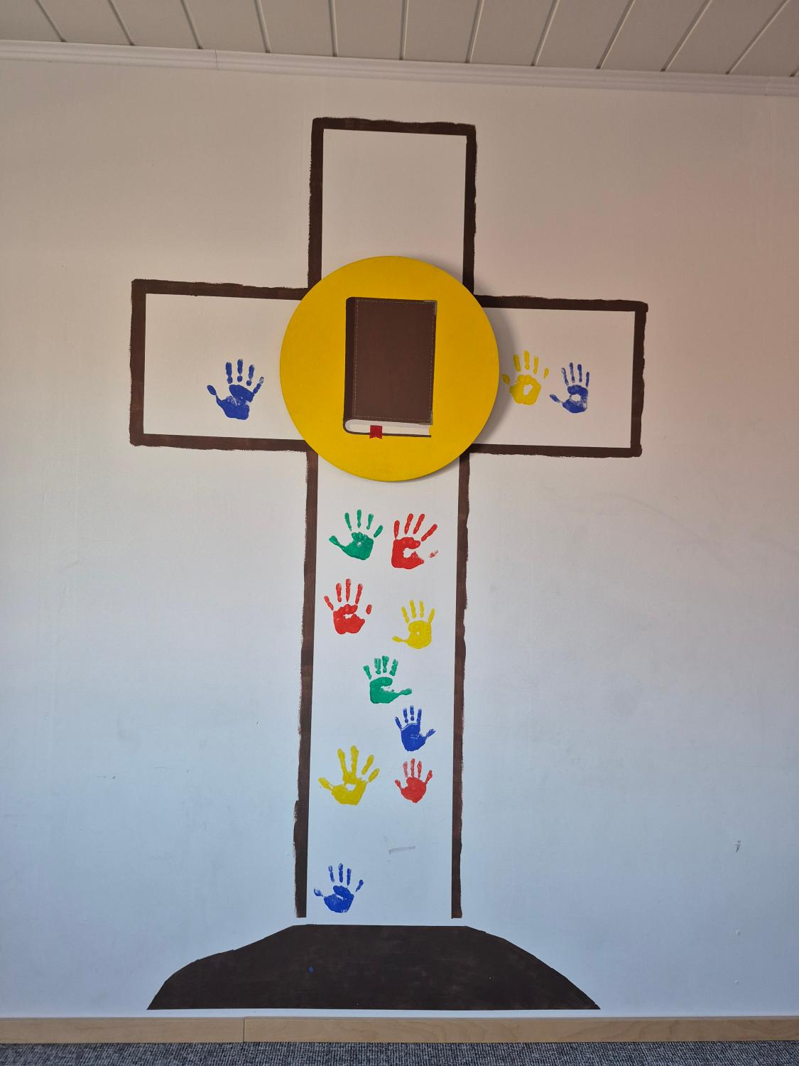 Kinderabenteuerland Kreuz mit bunten Handabdrücken